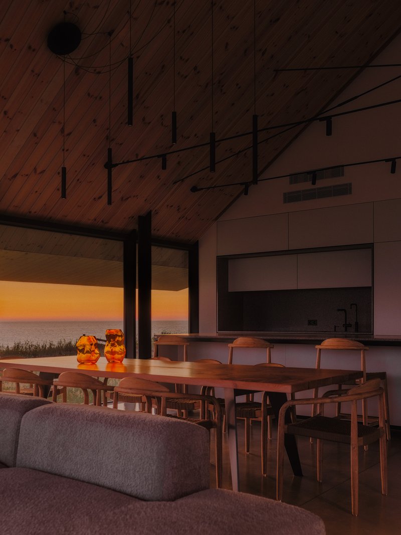 Living and dining space with vaulted wood ceiling framing sunset views over the landscape