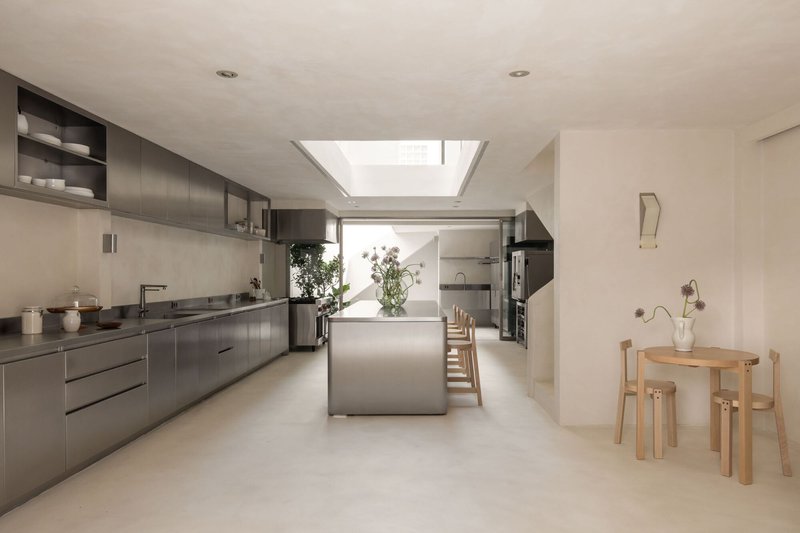 Open kitchen with stainless steel cabinetry and island beneath a rectangular skylight