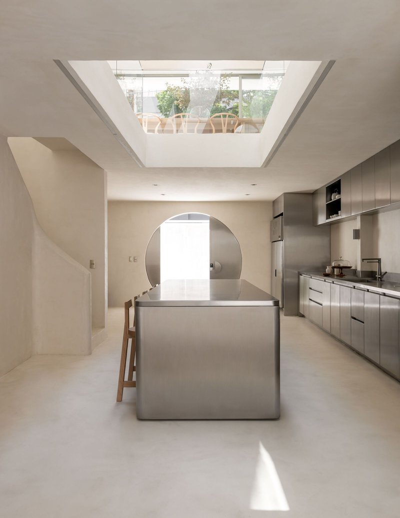 Kitchen island beneath a rectangular skylight framing a view of the rooftop terrace above
