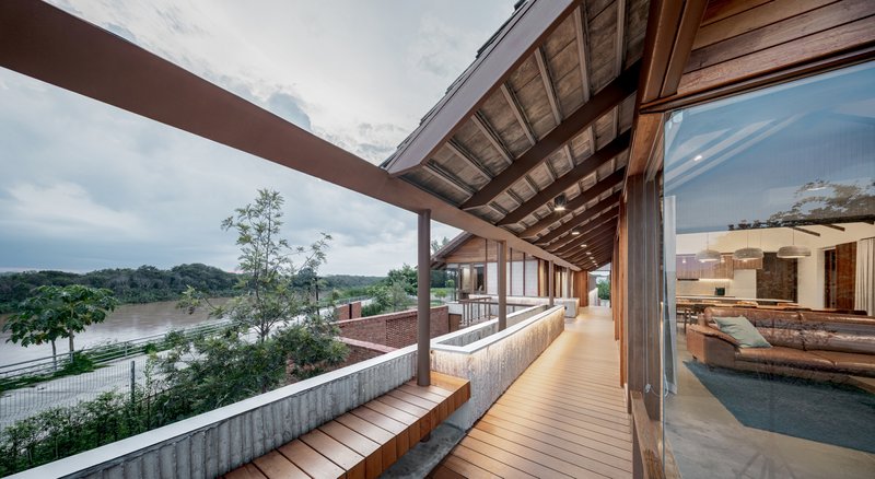 Covered timber deck terrace with river views and exposed timber rafters under cloudy skies