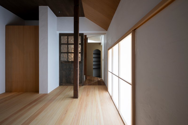 Upper floor hallway with translucent panel wall and exposed timber column at the turn