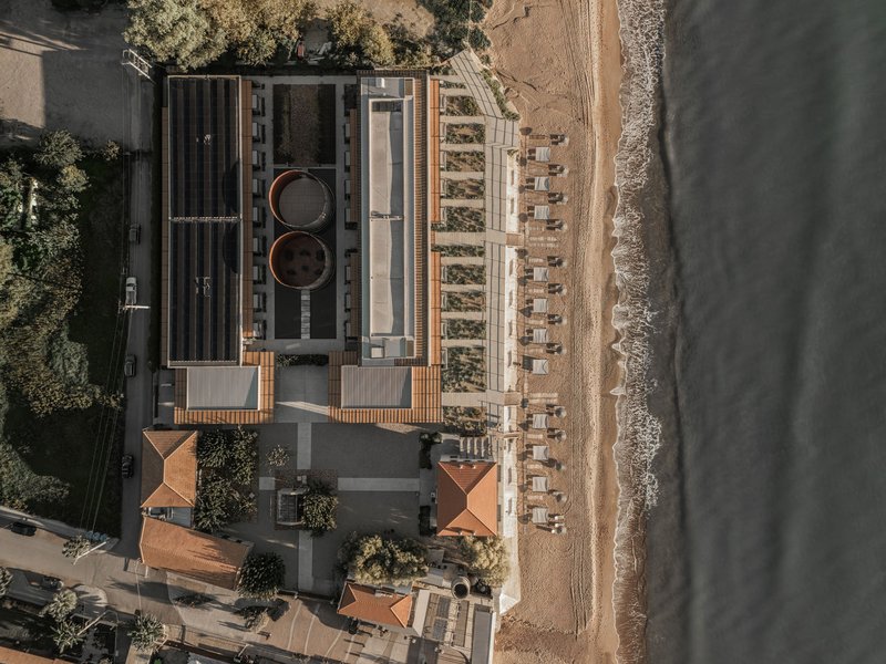 Drone view showing rooftop pools and timber canopy structure along the shoreline
