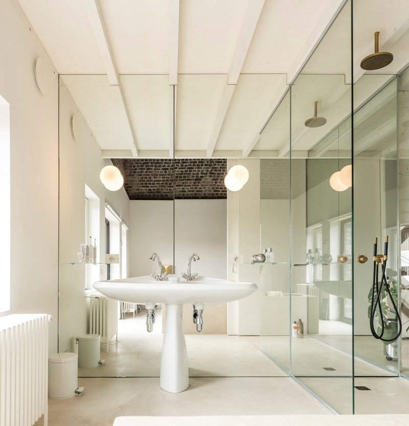 Bathroom with pedestal sink, painted wood beam ceiling, and floor-to-ceiling mirror reflecting the glass shower