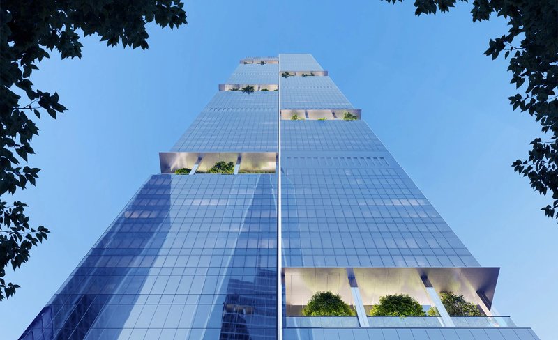 Worm's-eye view of the faceted glass facade with planted sky terraces framed by trees