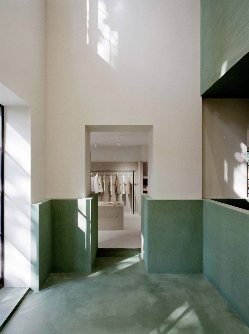 Stairwell with green plastered lower walls and white upper walls in morning sunlight