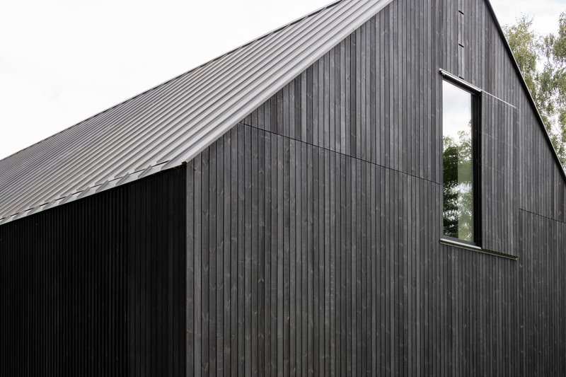 Close-up of the gabled form clad in vertical timber boards with a narrow vertical window