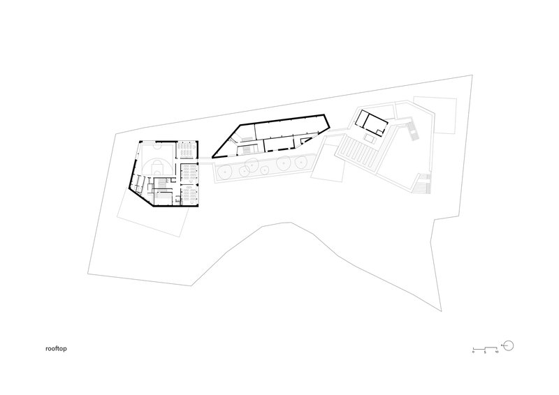 Rooftop plan drawing showing angular roof volumes with hatched auditorium seating area on one wing