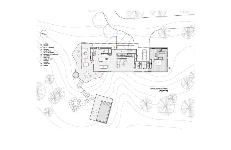 Site plan drawing depicting the main volume and detached structure within landscaped terrain and tree symbols