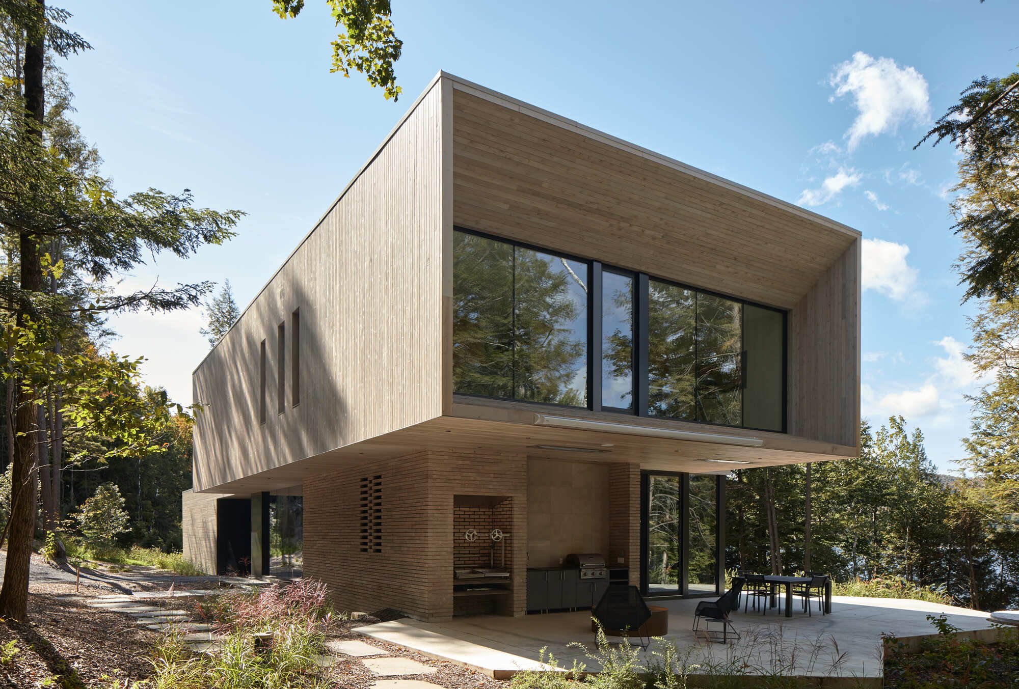 YH2 Architecture Stacks Two Wooden Blocks on a Rocky Outcrop Above Lake Memphremagog