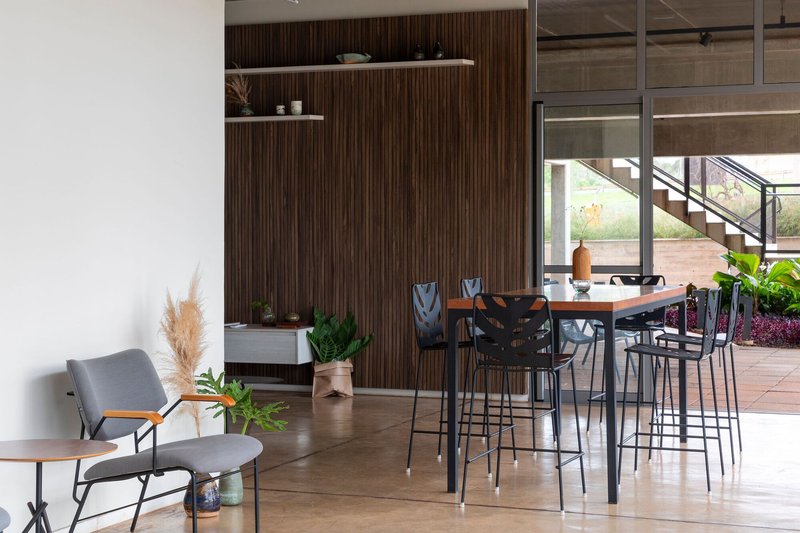 Breakroom with high table seating and vertical wood slat wall visible through a glass partition