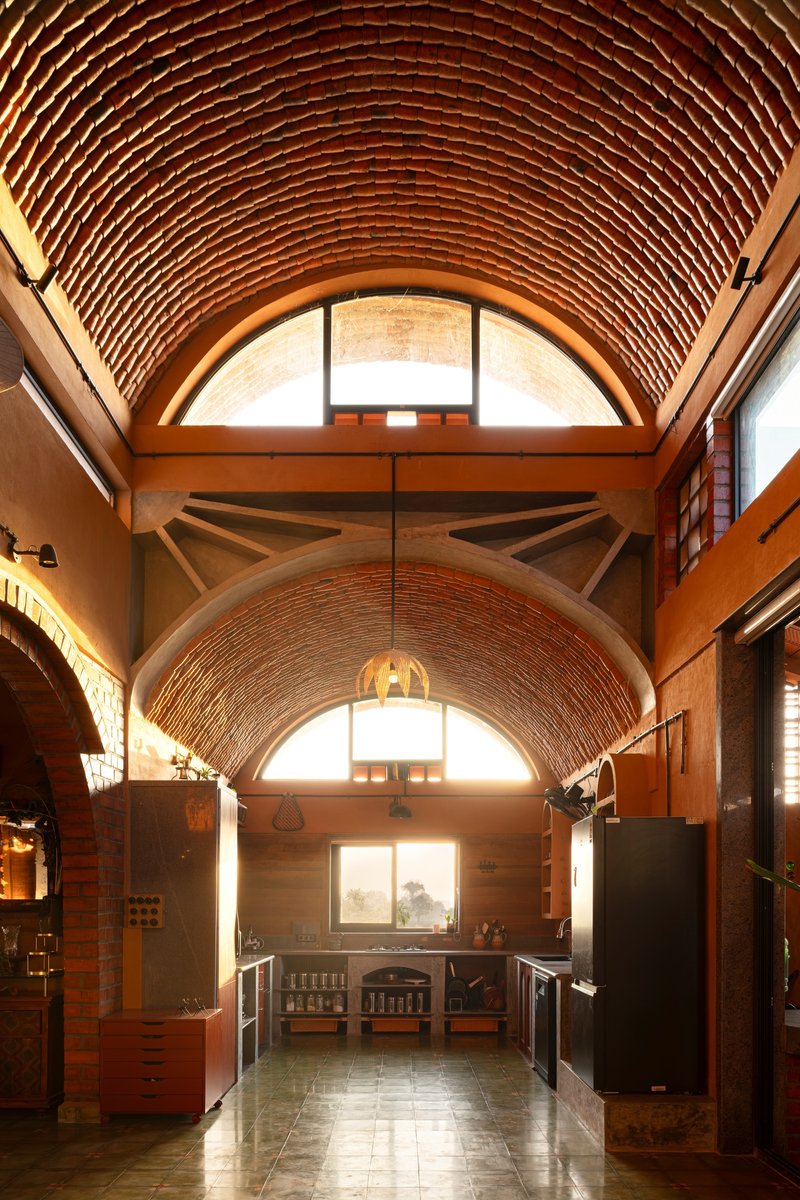 Interior corridor with exposed red brick barrel vault ceiling and clerestory windows letting in afternoon light