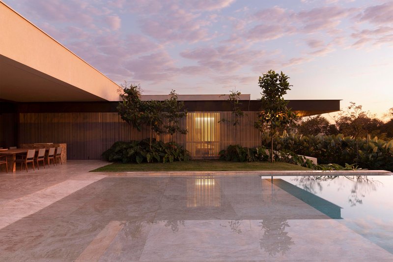 Pool deck with timber screen wall and reflecting water surface at twilight