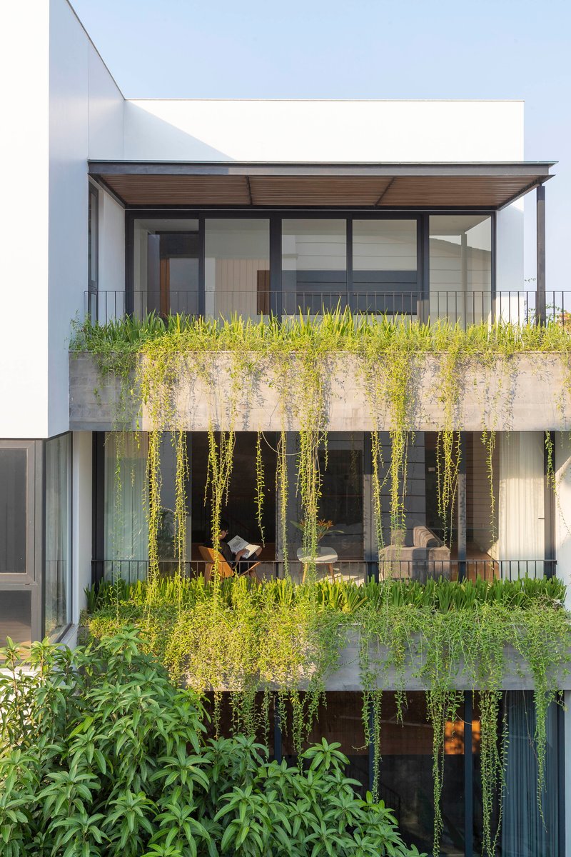 Garden facade with stacked concrete planters and cascading greenery spilling over multiple levels