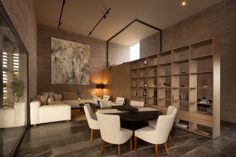 Double-height living room with horizontal timber wall cladding and built-in shelving beneath track lighting
