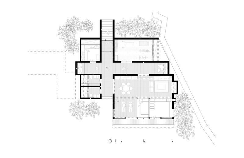 Floor plan drawing showing an open living area with central staircase and surrounding trees