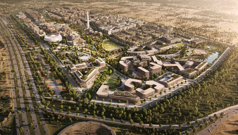 Aerial view of a master-planned campus with curved building blocks around green parks and sports fields at dusk