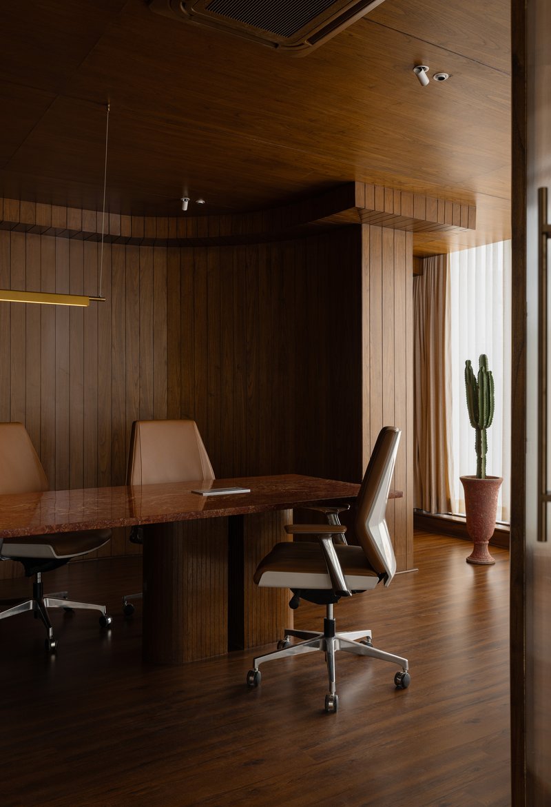 Dining area with timber wall paneling and linear pendant light above the table