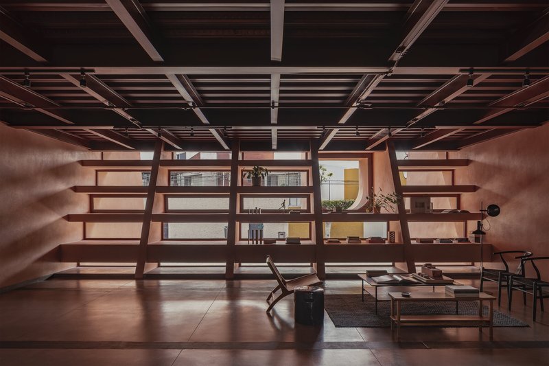 Open shelving unit with timber beams and exposed ceiling grid in afternoon light