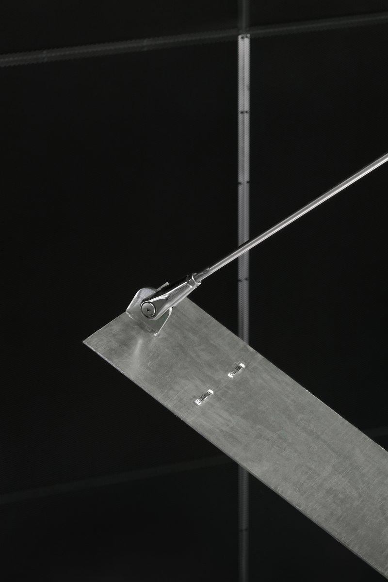Close-up of a steel rod tensioner connecting to a concrete stair tread