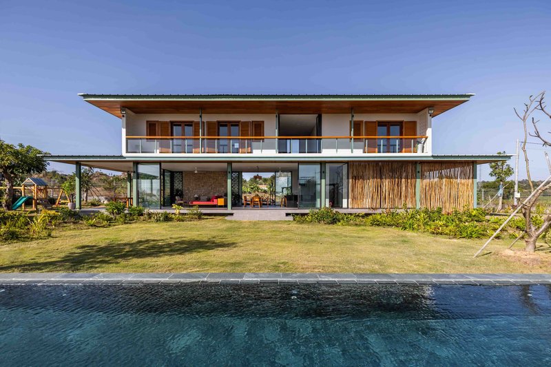 Two-story elevation across the reflecting pool showing open ground floor and enclosed upper balcony