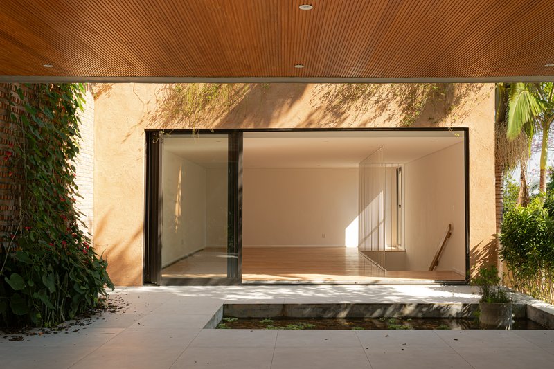 Covered terrace with timber slat ceiling and sliding glass doors opening to interior spaces