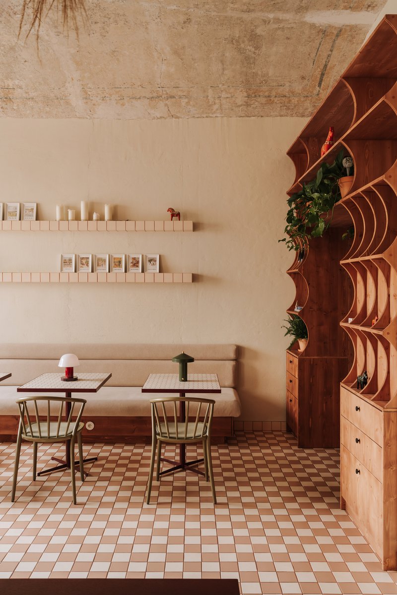 Dining area with chequered tile floor and curved timber shelving unit with integrated planters