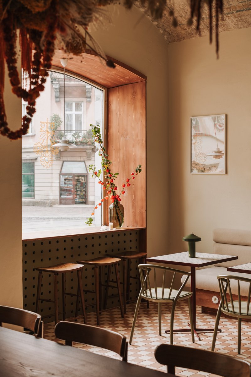 Timber-framed window nook with perforated metal panel and checkered tile floor overlooking the street