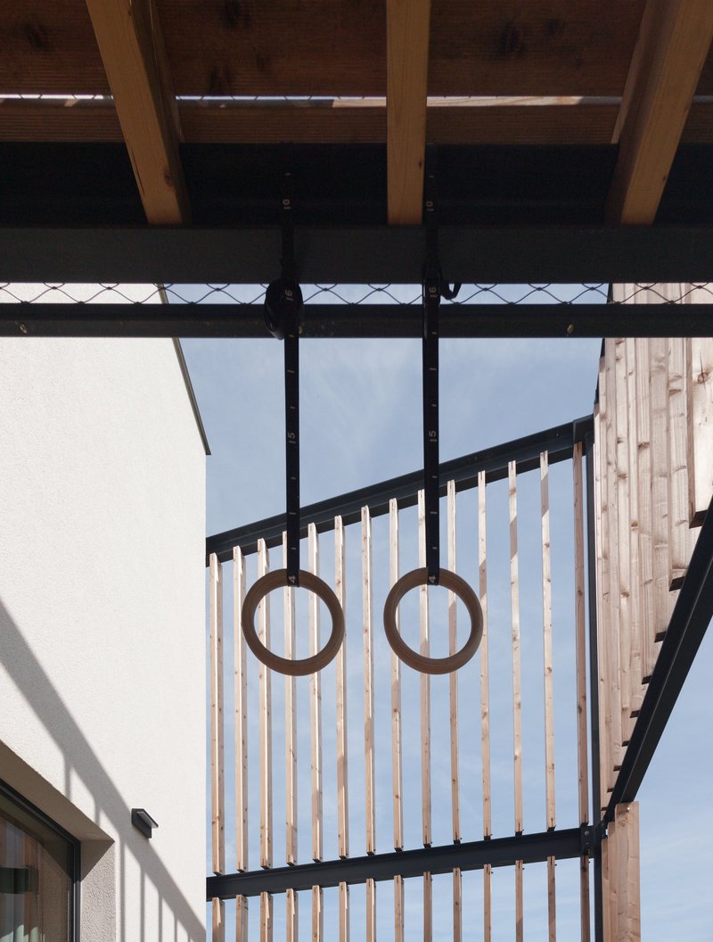 Layered timber facade filters light and views while creating a semi-private threshold between interior and exterior.