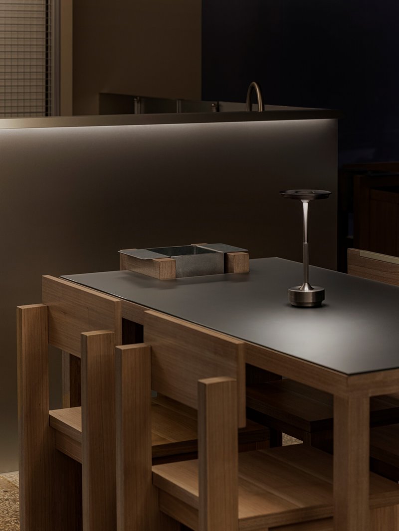 Close-up of oak dining table with matte grey surface and geometric timber base