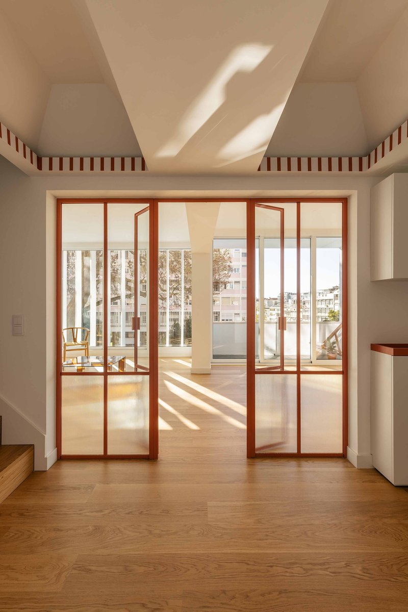 View through sliding glass doors with timber frames toward a balcony under afternoon light