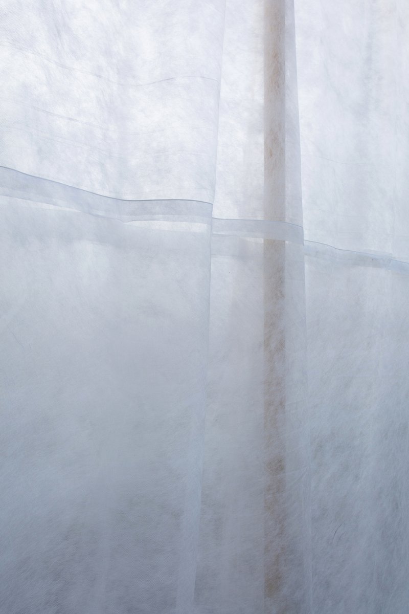 Close-up of overlapping translucent fabric panels showing seams and variations in texture