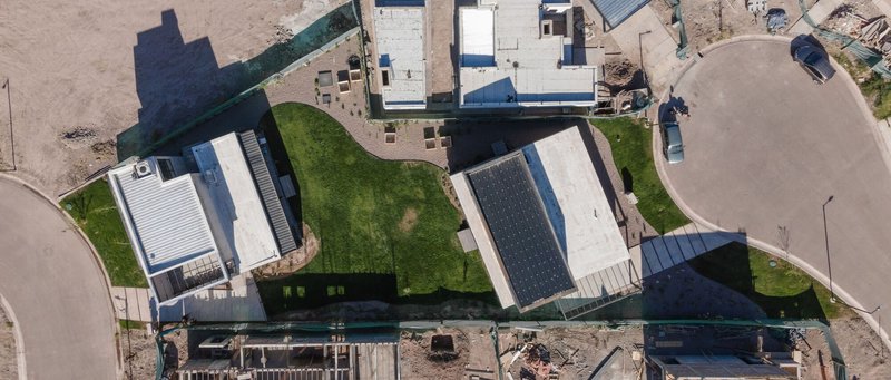 Aerial view of the two-story volume and its rear yard within the surrounding residential neighborhood