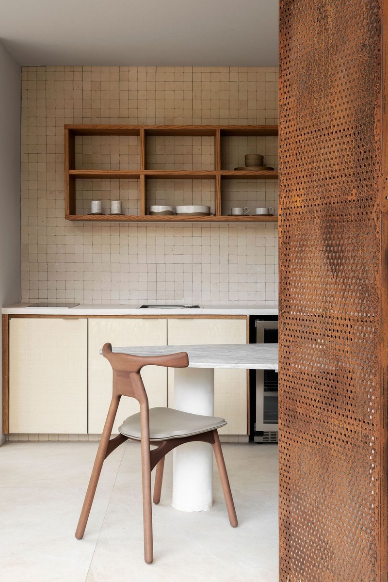 Kitchen nook with timber open shelving, perforated metal screen and pale stone tile backsplash