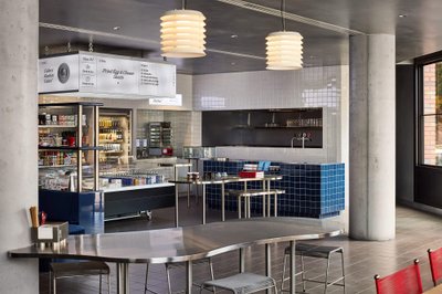 This is a photo of a modern restaurant or cafe interior. The space features stainless steel tables a
