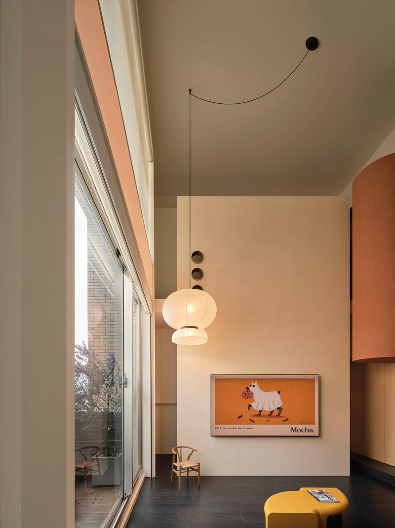 Double-height living space with floor-to-ceiling glazing overlooking a planted terrace