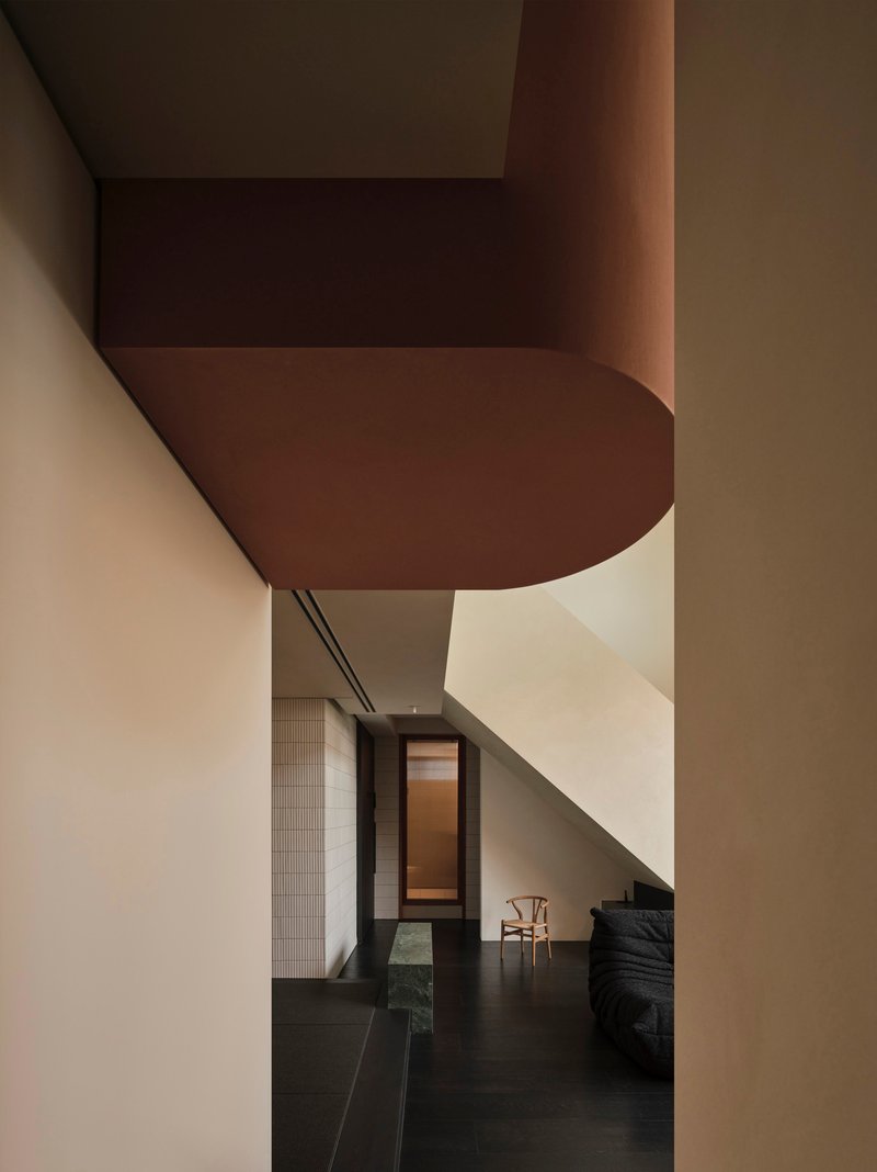 View through doorway showing rounded soffit detail and dark floor tiles in afternoon light