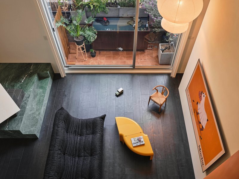 Overhead view of living room with glazed doors opening to planted terrace above