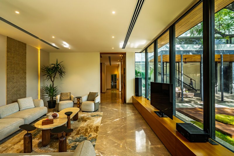 Living room with polished stone flooring and floor-to-ceiling glazing opening to the garden
