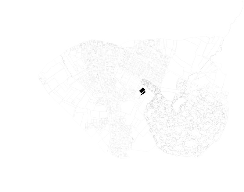 Site plan drawing showing a single building footprint within a detailed urban context