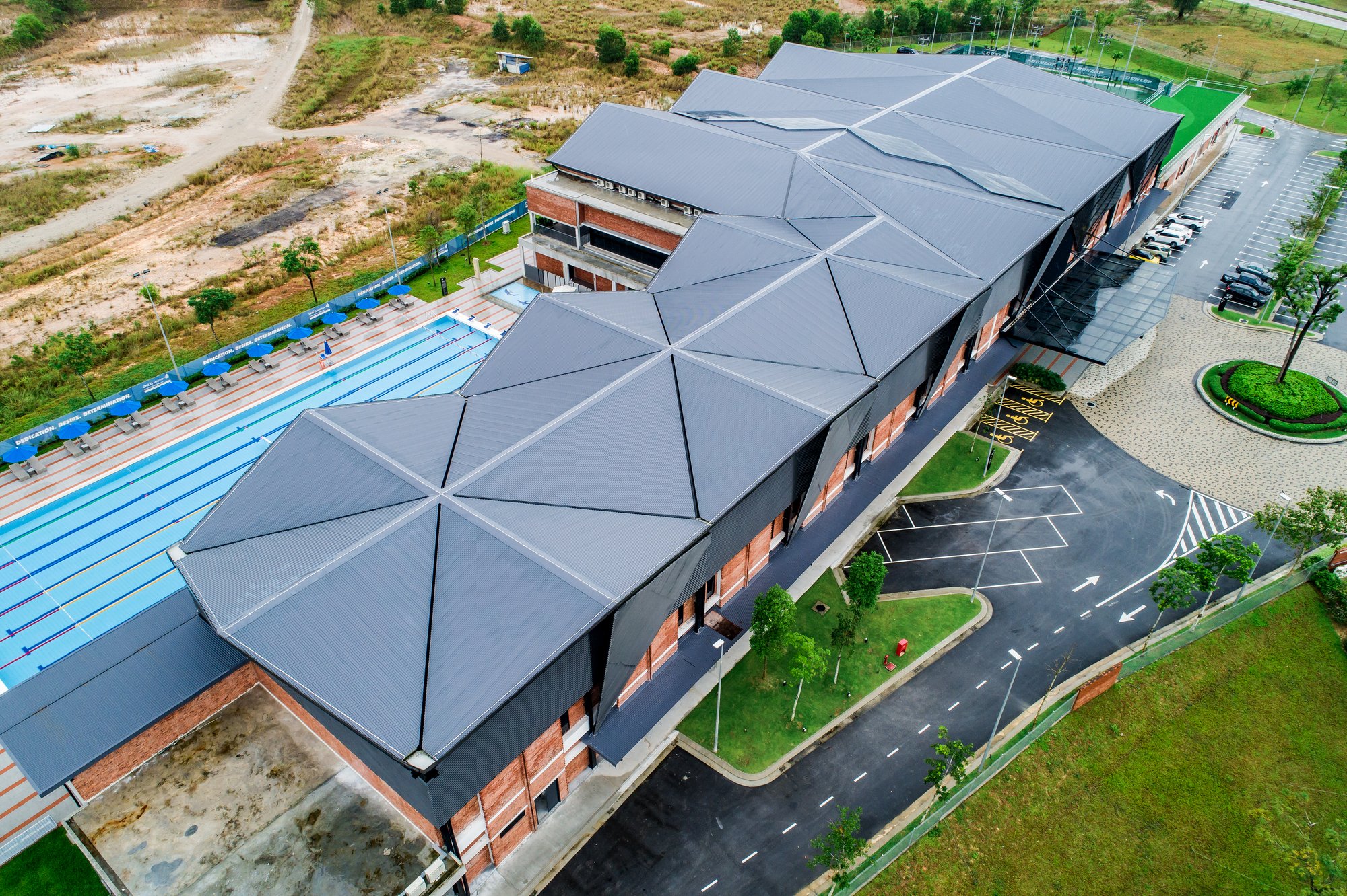 Archicentre Folds an Origami Roof Over a Brick Sports Complex in Iskandar Puteri