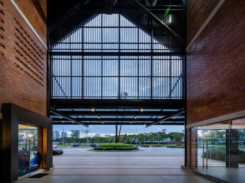 Interior atrium view with translucent corrugated wall and steel framing at twilight