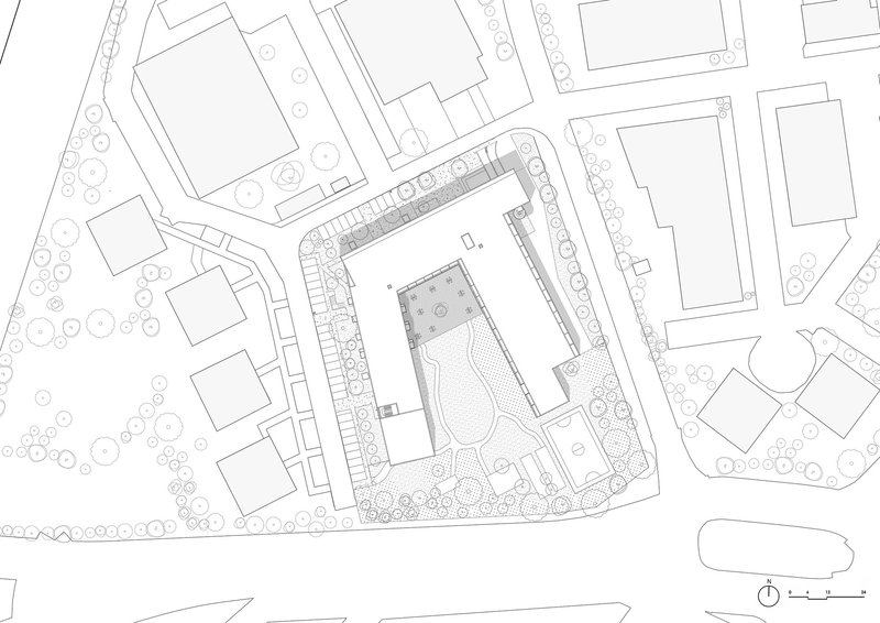 Site plan drawing showing residential building footprint with central courtyard surrounded by street trees