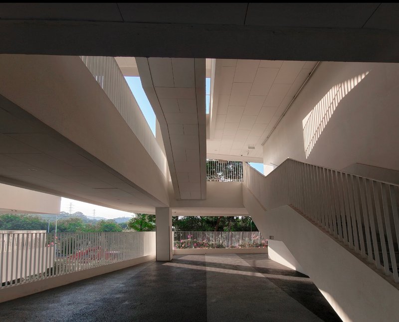 Ground level entry space with staircase and vertical slat screens filtering afternoon light