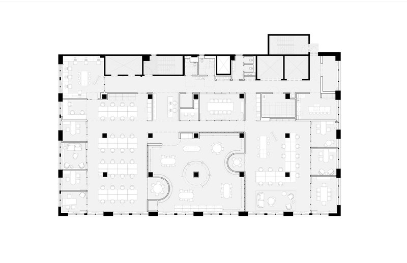 Floor plan drawing depicting an open office layout with workstations, meeting rooms, and curved interior partitions