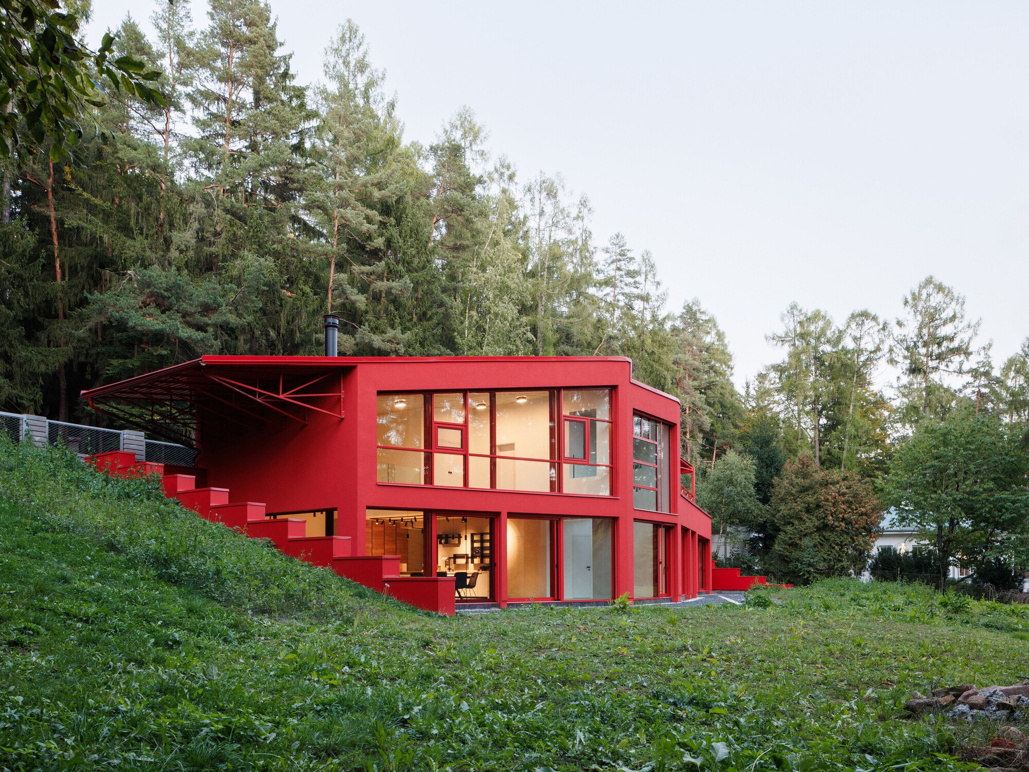 Architektura Sinks a Red Steel Villa into a Bohemian Forest Slope