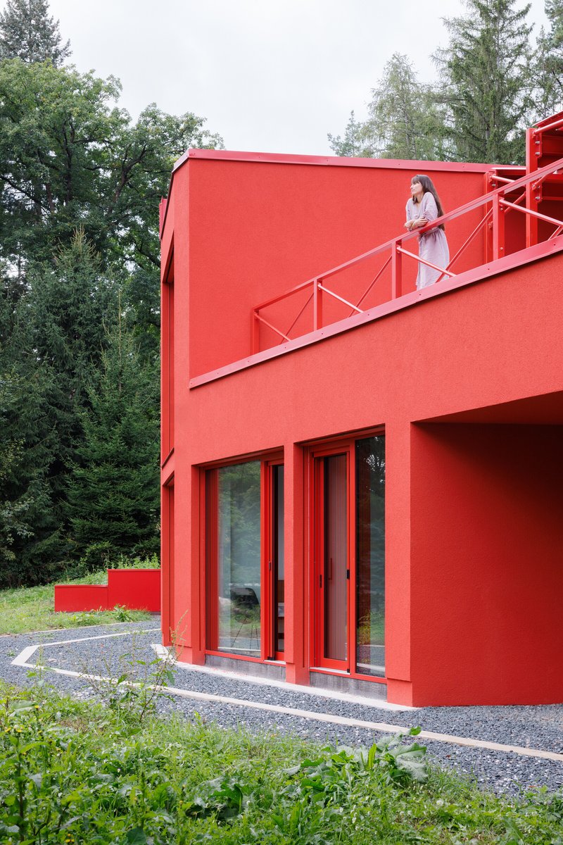 Person ascending the diagonal exterior staircase with metal railing under an overcast sky