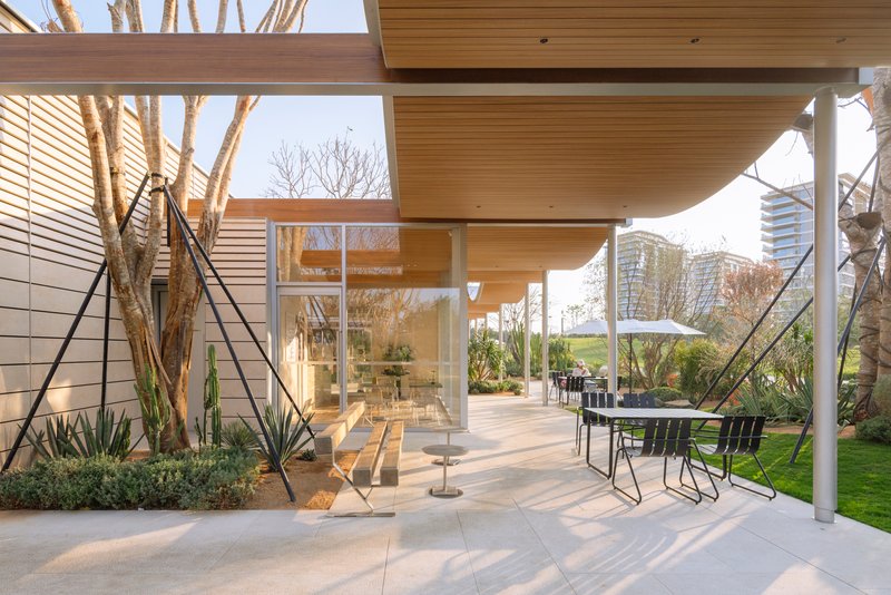 Covered outdoor patio with wood soffit looking through glass doors to bare winter trees