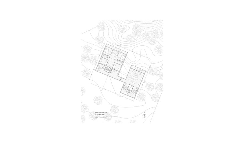 Ground floor plan drawing showing a rectangular building with interior rooms surrounded by topographic lines and vegetation