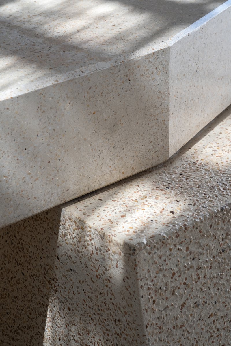 Detail of terrazzo steps with exposed aggregate finish in dappled natural light