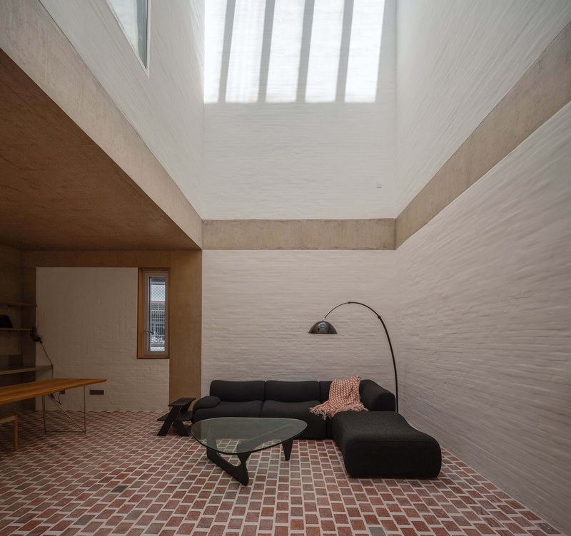 Interior courtyard space with terracotta tile floor and vertical skylight slats diffusing natural light